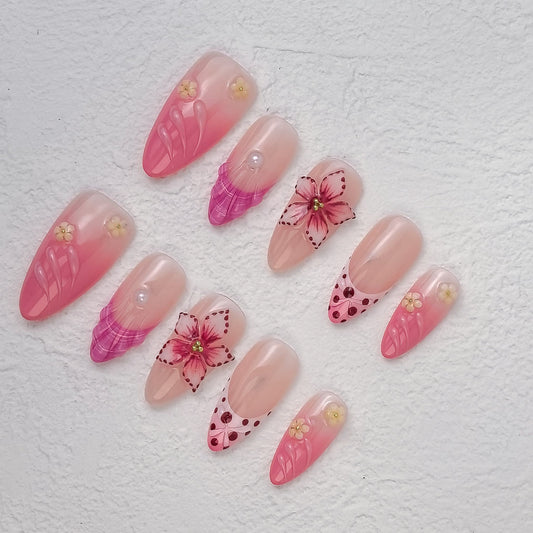 Close top-view of Petal Fiesta nails featuring hot-pink feathered tips, dotted hearts and raised flowers