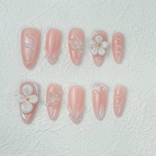 Pink floral press-on nails with 3D flowers and pearl details, flat layout